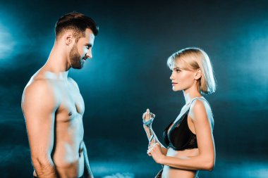 şehvetli çift mavi dumanlı arka plan üzerinde kelepçe ile poz