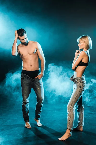 上半身裸の男と官能的な女性が煙のような青の背景にポーズ — ストック写真