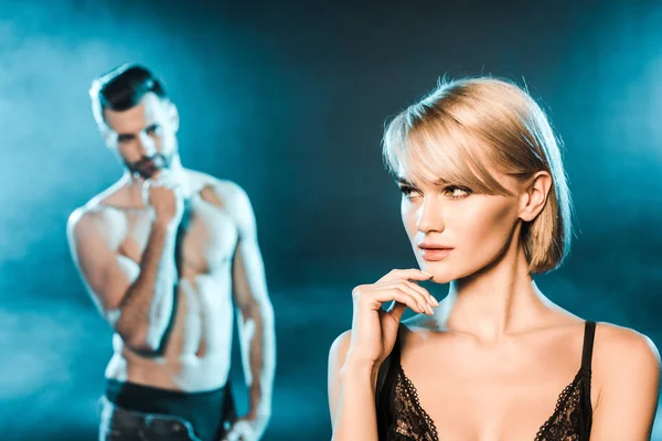 çekici genç kadın mavi dumanlı arka plan üzerinde yakışıklı erkek arkadaşı ile poz