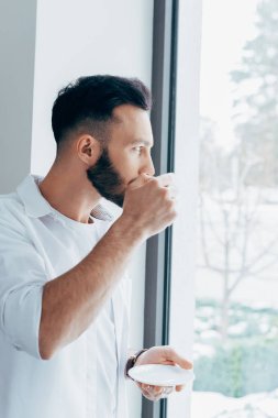 Kahve içme ve penceresine bakarak ciddi adam