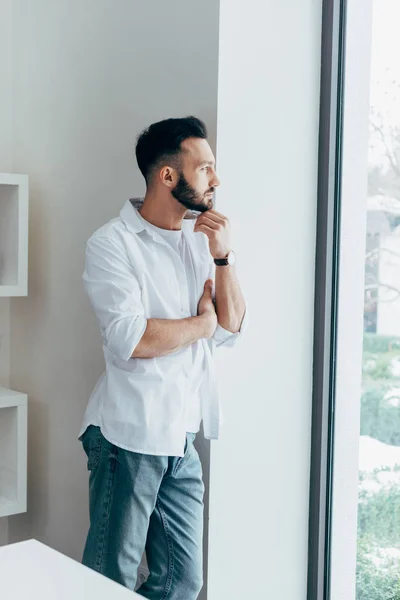 Dreamy Young Man Touching Beard Looking Window — Stock Photo, Image