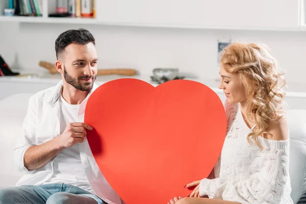 Romantyczna Para Siedzi Kanapie Duże Czerwone Serce — Zdjęcie stockowe