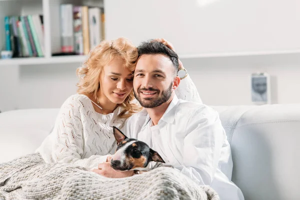 Glückliches Paar Sitzt Mit Lustigem Hund Auf Sofa — Stockfoto