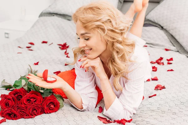 Happy Blonde Girl Lying Bed Flowers Holding Ring — Stock Photo, Image