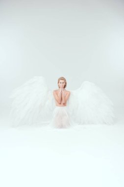 melek güzel kadına jest dua ve üzerinde beyaz izole kamera bakarak yapıyor kanatlar