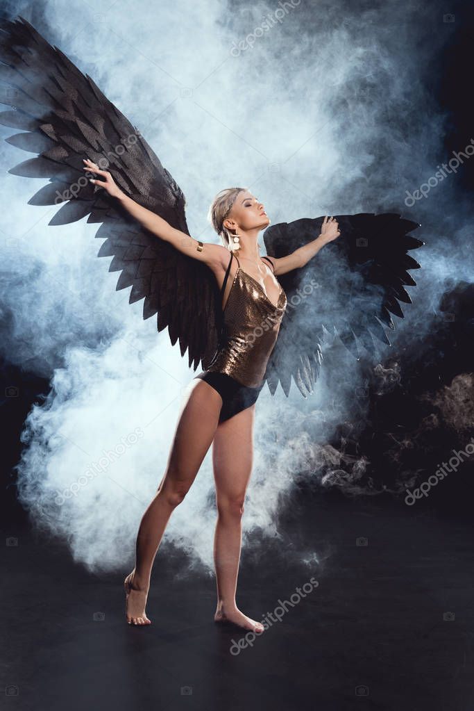 Beautiful Sexy Woman With Black Angel Wings And Outstretched Hands Posing On Black Background Larastock Beautiful Sexy Woman With Black Angel Wings And Outstretched Hands Posing On Black Background Larastock