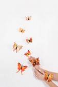 oříznutý pohled ženy poblíž oranžové motýlů na bílém pozadí, ekologické ukládání konceptu 
