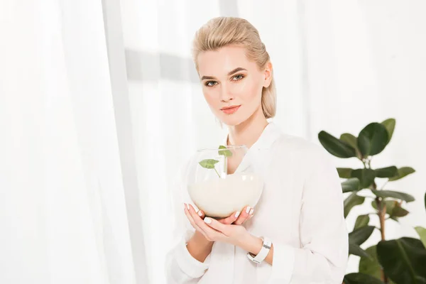 Attraktiv Kvinna Håller Fiskskål Med Sand Och Gröna Blad Miljömässiga — Stockfoto