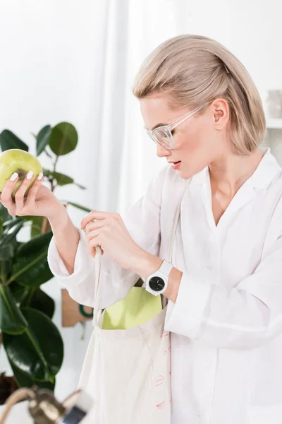 Όμορφη Επιχειρηματίας Ποτήρια Κρατώντας Πράσινο Μήλο Και Ψάχνει Μέσα Τσάντα — Φωτογραφία Αρχείου