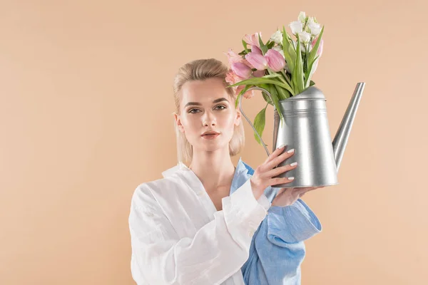 ベージュ 環境保存の概念に分離された花の水まき缶を押しながらエコ服で立っている美しい少女 — ストック写真
