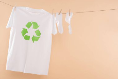  clothesline yakınındaki beyaz çorap bej, çevre tasarrufu konsepti üzerine izole işareti geri dönüşüm ile t-shirt