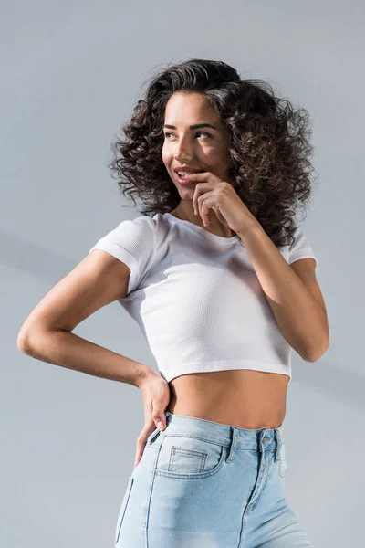 Drömmande Curly Flicka Jeans Bita Fingret Grå Bakgrund — Stockfoto