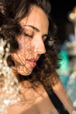 Kıvırcık rahat kadın kapalı gözler ile arka plan bulanıklık