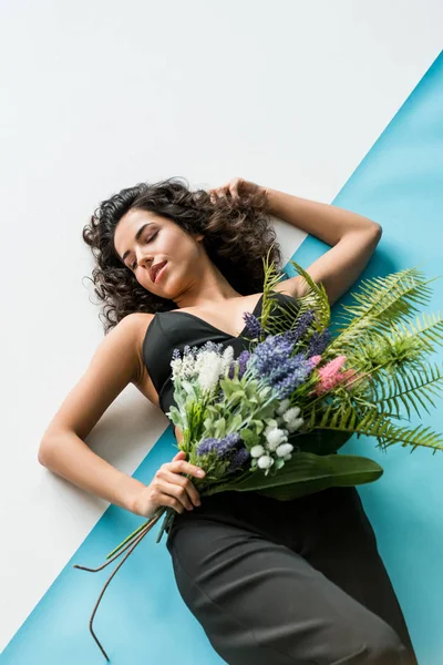 Ontspannen Krullend Vrouw Met Bloemen Liggen Witte Blauwe Achtergrond — Stockfoto