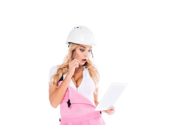 surprised attractive handy woman in pink uniform, taking off glasses and looking to digital tablet isolated on white clipart