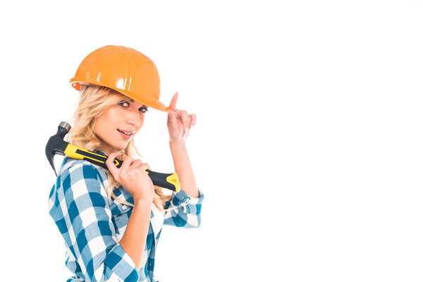 blonde handy woman in blue shirt and orange hardhat with hammer isolated on white