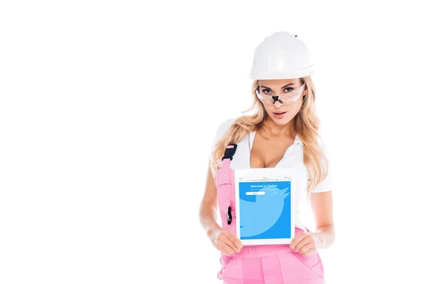 方便的女人在粉红色的制服和眼镜拿着数字平板电脑与推特应用程序在屏幕上隔离在白色 — 图库照片