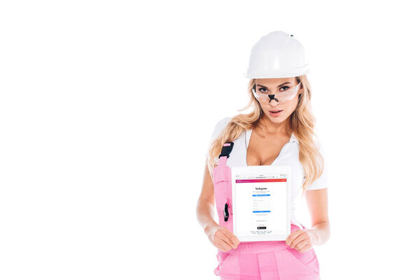 handy woman in pink uniform and glasses holding digital tablet with instagram app on screen isolated on white