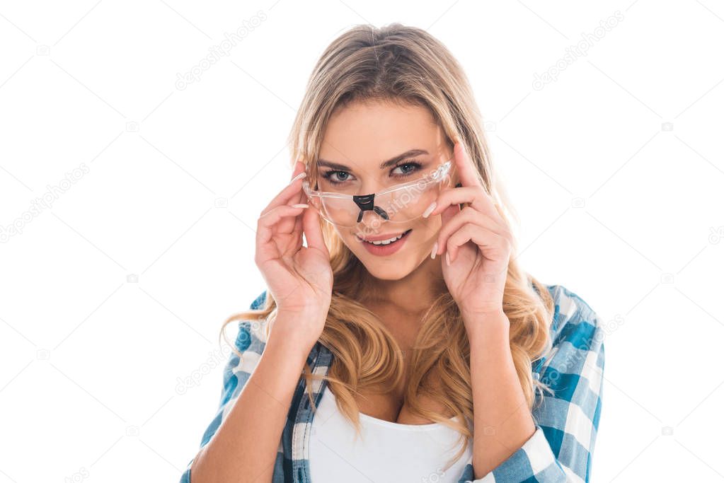 blonde woman in green shirt putting on glasses isolated on white