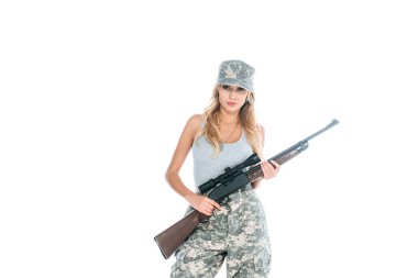 militarywoman in grey t-shirt, camouflage pants and cap holding weapon isolated on white clipart