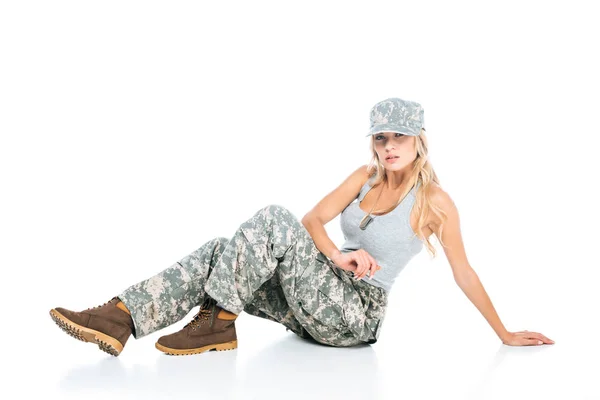 グレーの シャツ 迷彩のパンツと白い背景の上に座ってキャップで金髪 Militarywoman — ストック写真