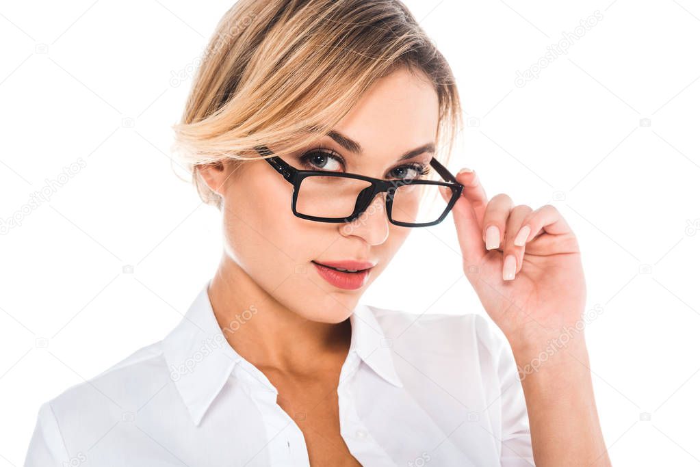 attractive blonde teacher in blouse putting on glasses isolated on white
