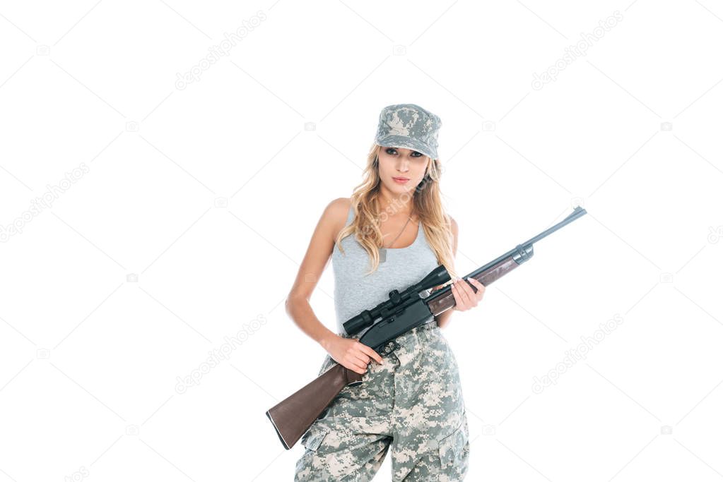militarywoman in grey t-shirt, camouflage pants and cap holding weapon isolated on white