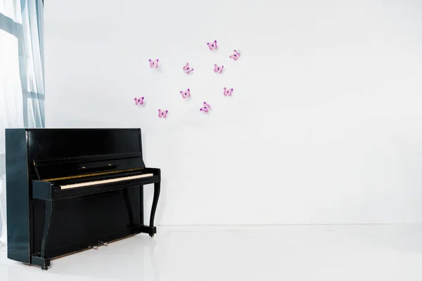 Piano Negro Sobre Fondo Blanco Con Mariposas Púrpuras Espacio Copia — Foto de Stock