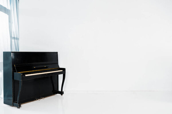 черный фортепиано на белом фоне с копировальным пространством
