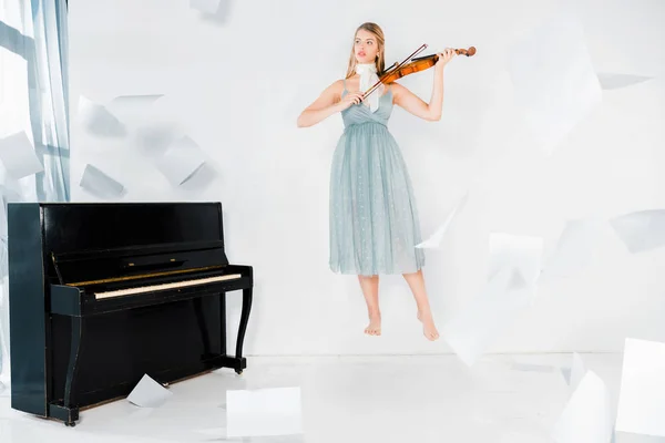 Πλωτή Κορίτσι Μπλε Φόρεμα Παίζει Βιολί Φύλλα Χαρτιού Στον Αέρα — Φωτογραφία Αρχείου