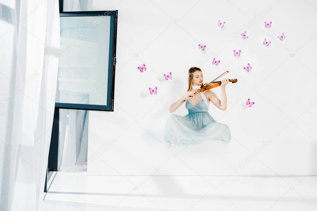 floating girl in blue dress playing violin on white background 