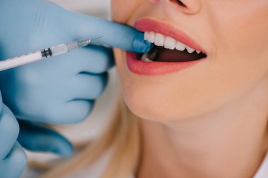 kadın için lokal anestezi enjeksiyon veren diş hekimi görünümünü kırpılmış
