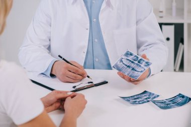 ortodontist diş Kliniği Bayan hasta ile istişare sırasında x-ışını ve yazma tanı tutan kırpılmış görünümünü 