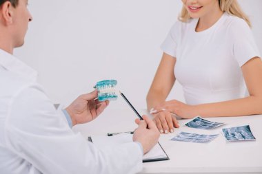 çene modeli ile üzerine beyaz izole kadın Danışma sırasında işaret ortodontist kırpılmış görünümünü