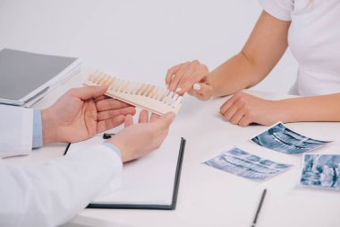 kadının üzerinde beyaz izole dişçi ile istişare sırasında diş renk paleti, parmağınızla işaret kırpılmış görünümü
