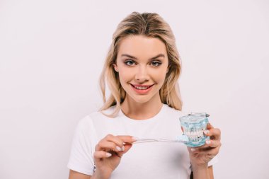 çene modeli diş fırçası ile fırçalama ve üzerinde beyaz izole kamera bakıyor güzel gülümseyen kadın