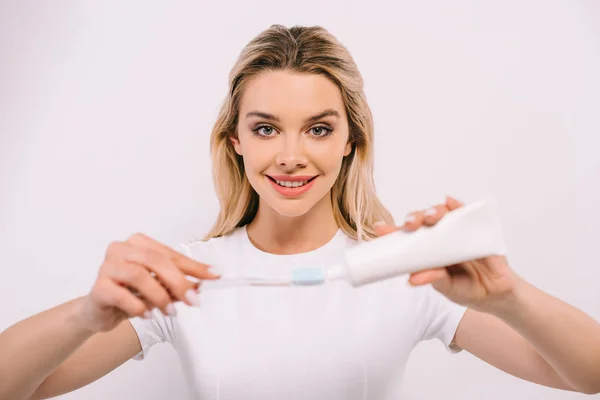 白で隔離の歯ブラシに歯磨き粉を入れて笑顔美人 — ストック写真