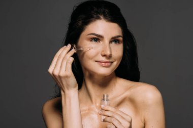 gri izole pipet ile serum uygulayarak çekici çıplak kadın