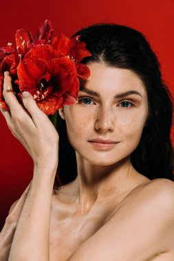 Yüzündeki kırmızı izole nergis zambağı çiçekli poz çilli güzel kadın