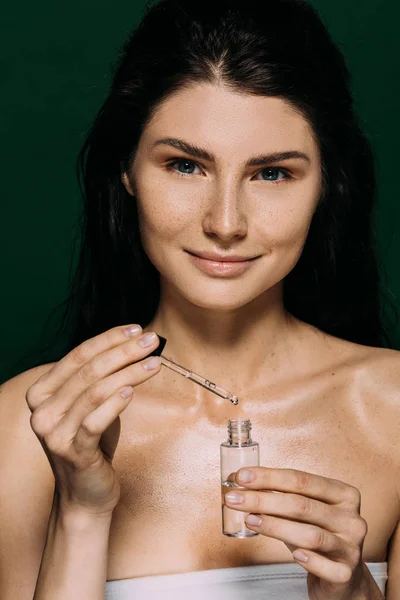 Lachende Aantrekkelijke Vrouw Met Fles Met Serum Geïsoleerd Groen — Stockfoto