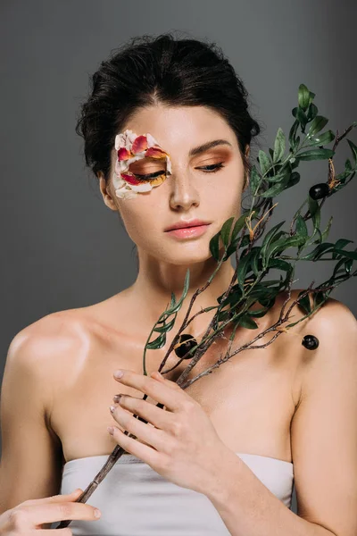 Mooie Vrouw Met Bloemblaadjes Gezicht Met Groene Tak Geïsoleerd Grijs — Stockfoto