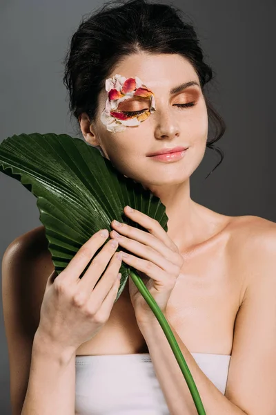 Marzycielski Kobieta Zamkniętymi Oczami Płatki Kwiatów Twarzy Przytrzymując Zielony Liść — Zdjęcie stockowe