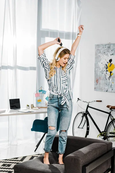 Excited Girl Headphones Dancing Sofa Waving Hands — Stock Photo, Image