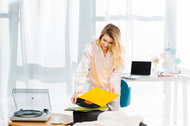 Saten pijama vinil kaydı sabah holding gülümseyen kadın