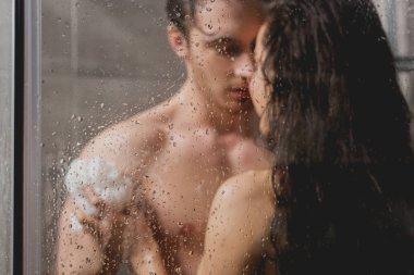 seçici odak erkek ve sarılma ve banyo lif kabağı kabin içinde güzel kadın 