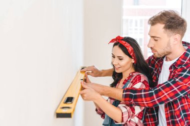 Çift holding evde duvarının yakınında seviyesi ölçümü