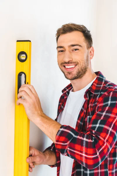 Cheerful Handyman Holding Measuring Level Home — Stock Photo, Image