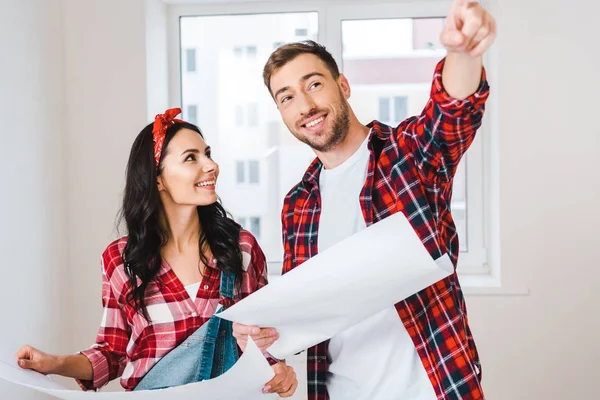 Mooie Vrouw Zoek Naar Man Met Vinger Wijzen Terwijl Blauwdruk — Stockfoto