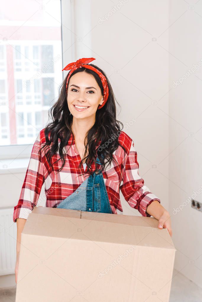 happy woman holding box and smiling at home