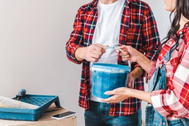 adam boya kovası alarak ve kadının yanına evde duran kırpılmış görünümü